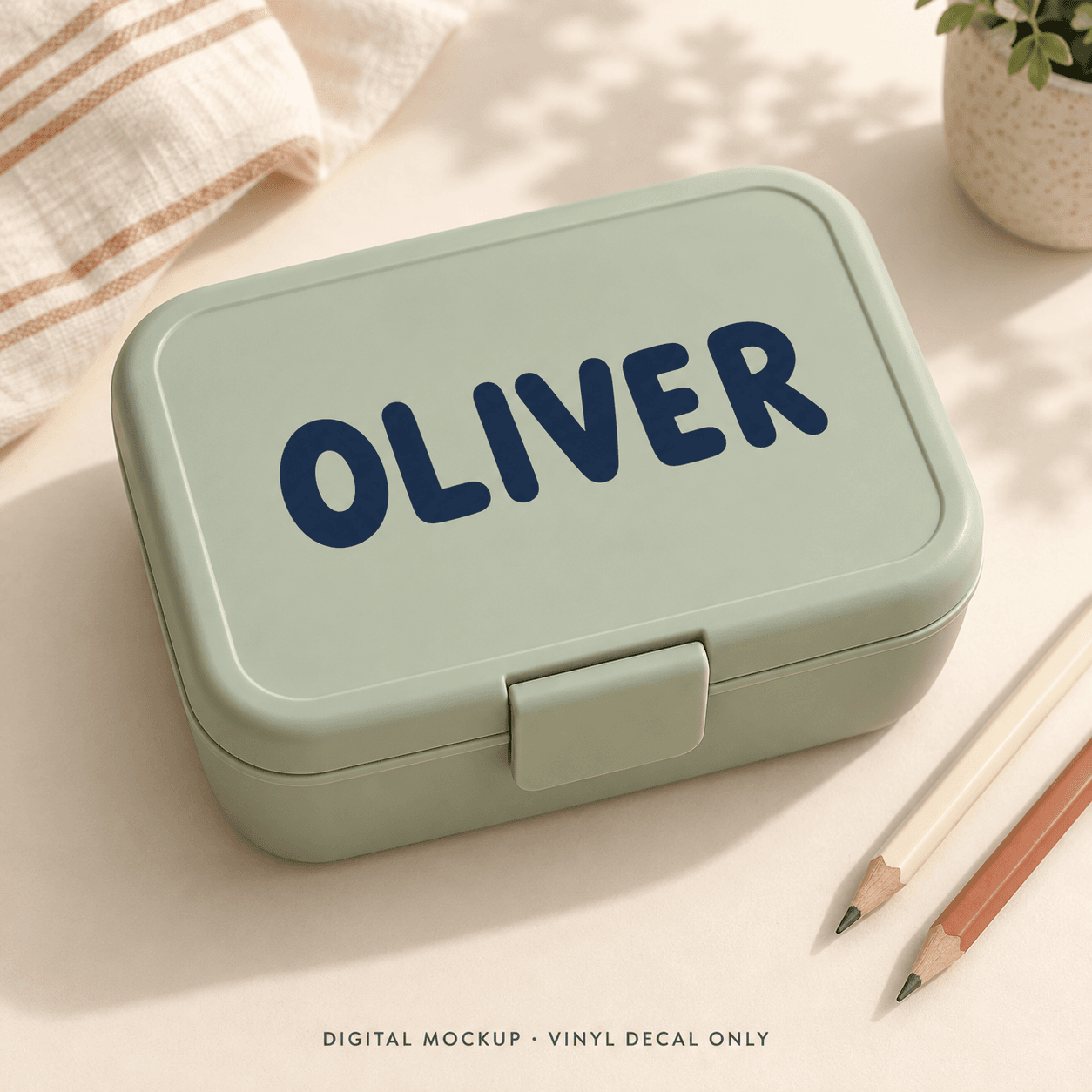 Digital mockup: Navy name "OLIVER" on a sage lunchbox. Vinyl decal only; props are not included.